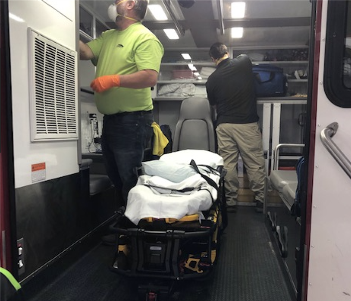 a guy cleaning the inside of an ambulance