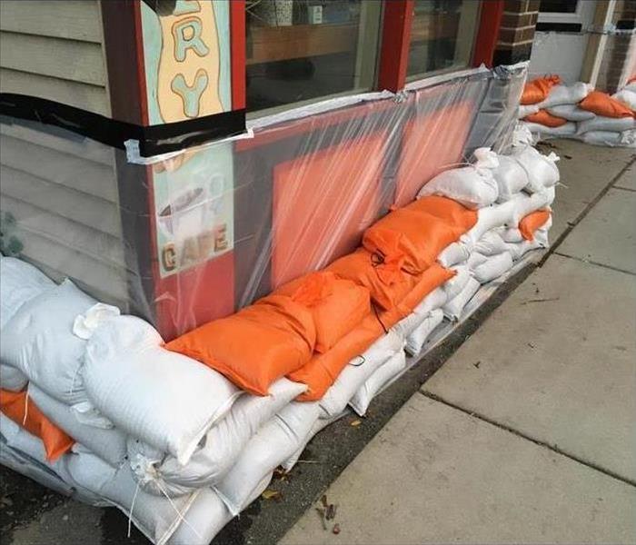 A business protected from flooding with sand bags and plastic film